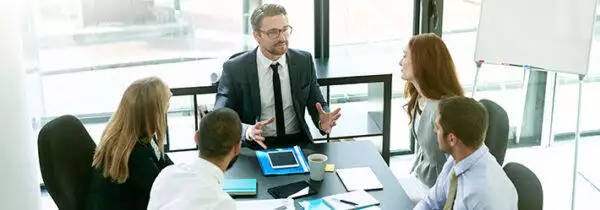 Health care business people in a board room discussing improving the patient referral process.