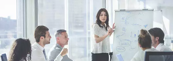 A woman Delivering Mission-Critical EDI in front of her workmates and boss