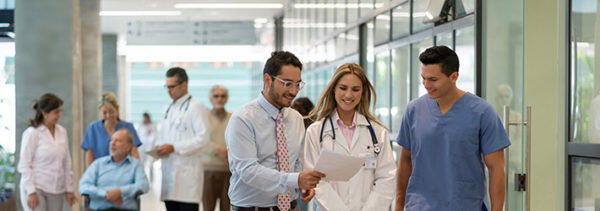 healthcare professionals walking along the hospital main hall while discussing about New Position Control System
