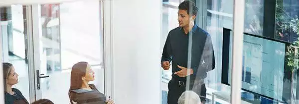 A man presenting a financial planning in front of his workmates in a meeting room