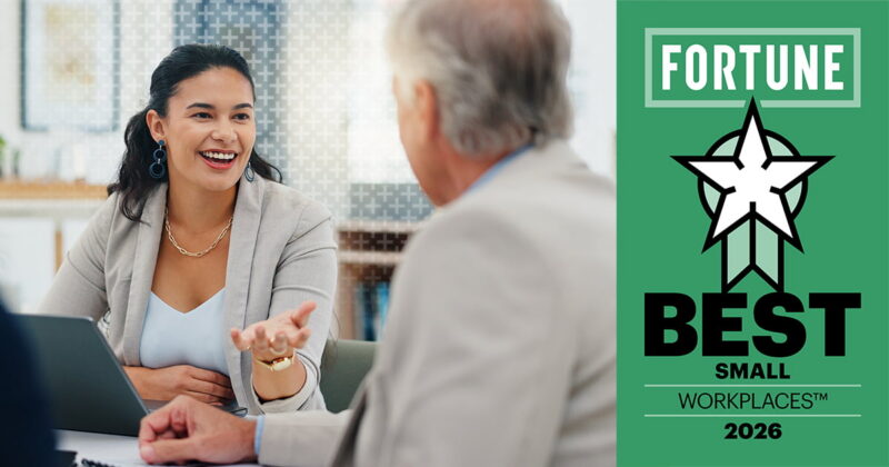Smiling woman in a blazer speaks with an older man across a laptop, beside a green Fortune Best Small Workplaces 2026 award graphic.
