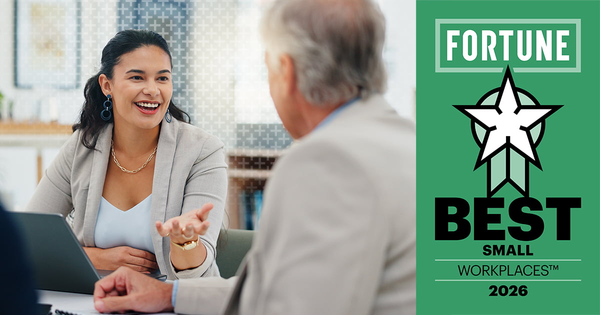 Smiling woman in a blazer speaks with an older man across a laptop, beside a green Fortune Best Small Workplaces 2026 award graphic.